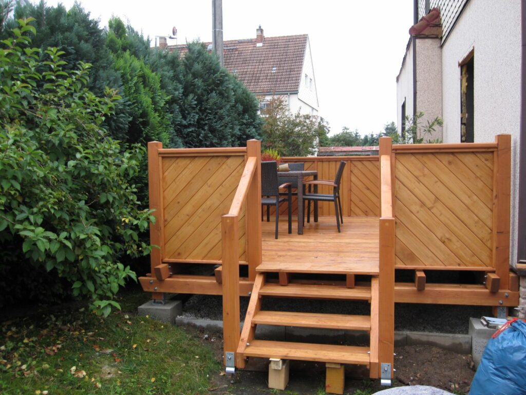 Holzterrasse mit Treppenzugang zum Garten
