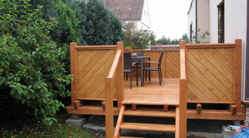 Holzterrasse mit Treppenzugang zum Garten