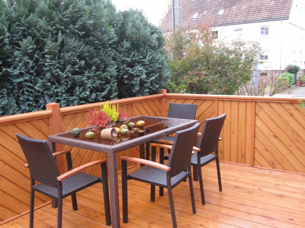 Holzterrasse mit Treppenzugang zum Garten